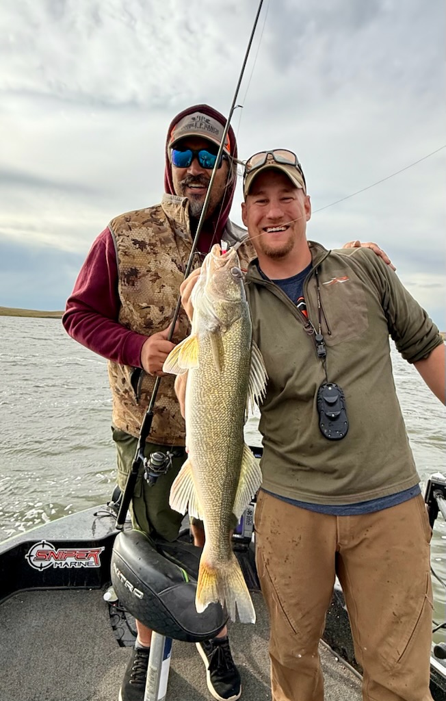 Two anglers holding a trophy walleye caught on a guided South Dakota fishing trip at Double P Ranch