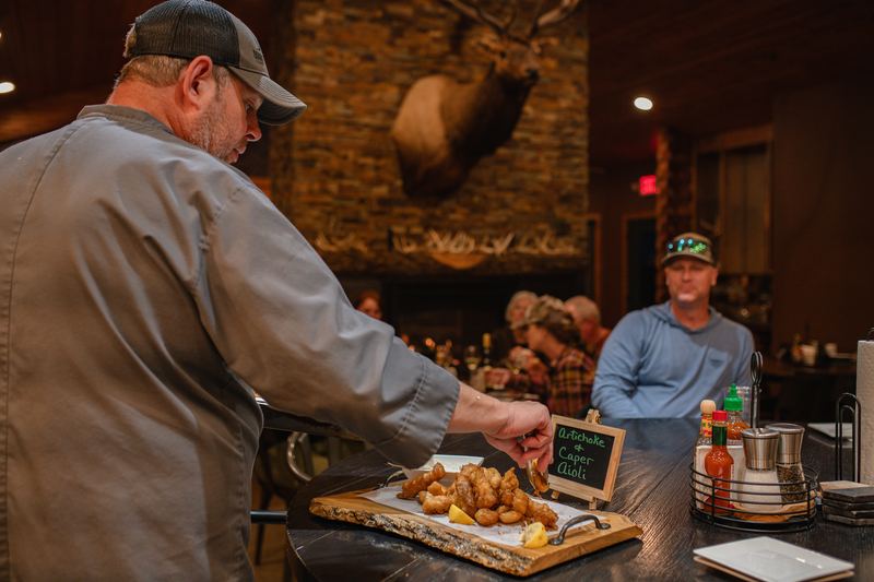 Double P Ranch chef serving appetizers with artichoke caper aioli at the lodge bar